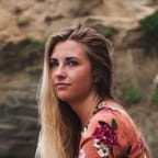 Blond girl on the rocky beach